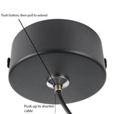 Zwarte plafondkap met verstelbaar kabelmechanisme, onderaanzicht met aanduidingen voor het verlengen en verkorten van de kabel via drukknop.