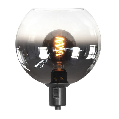 Frontale aanzicht van een moderne bolvormige tafellamp met een glazen smoke grijze kap en zichtbare spiraalvormige LED filament lichtbron.
