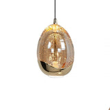 Gouden glazen hanglamp in druppelvorm met luchtbel-effect, vooraanzicht, moderne designverlichting voor woonkamer of eetkamer.