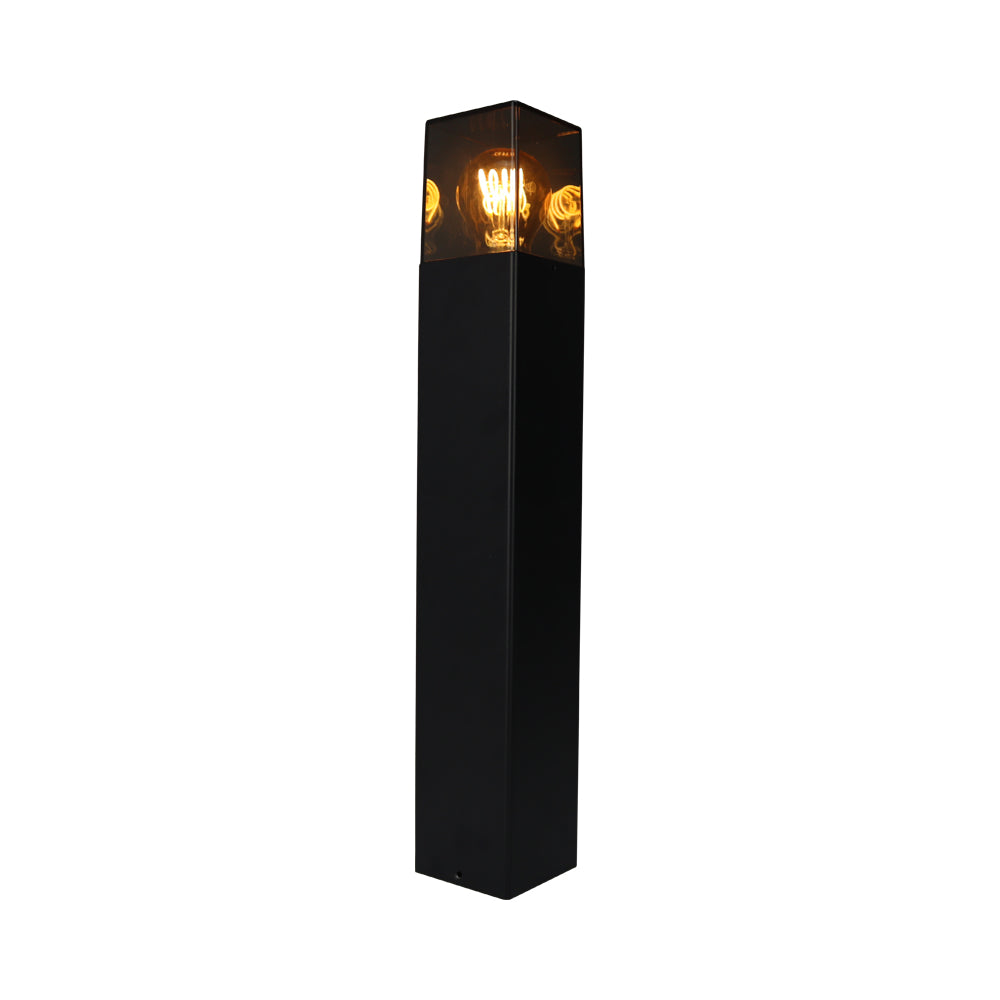 Zwarte vierkante buitenlamp sokkel met helder venster en zichtbare filamentlamp, schuin vooraanzicht.