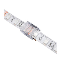 Close-up afbeelding van een transparante LED strip connector aangesloten op een witte 4-pins LED strip, schuin bovenaanzicht.