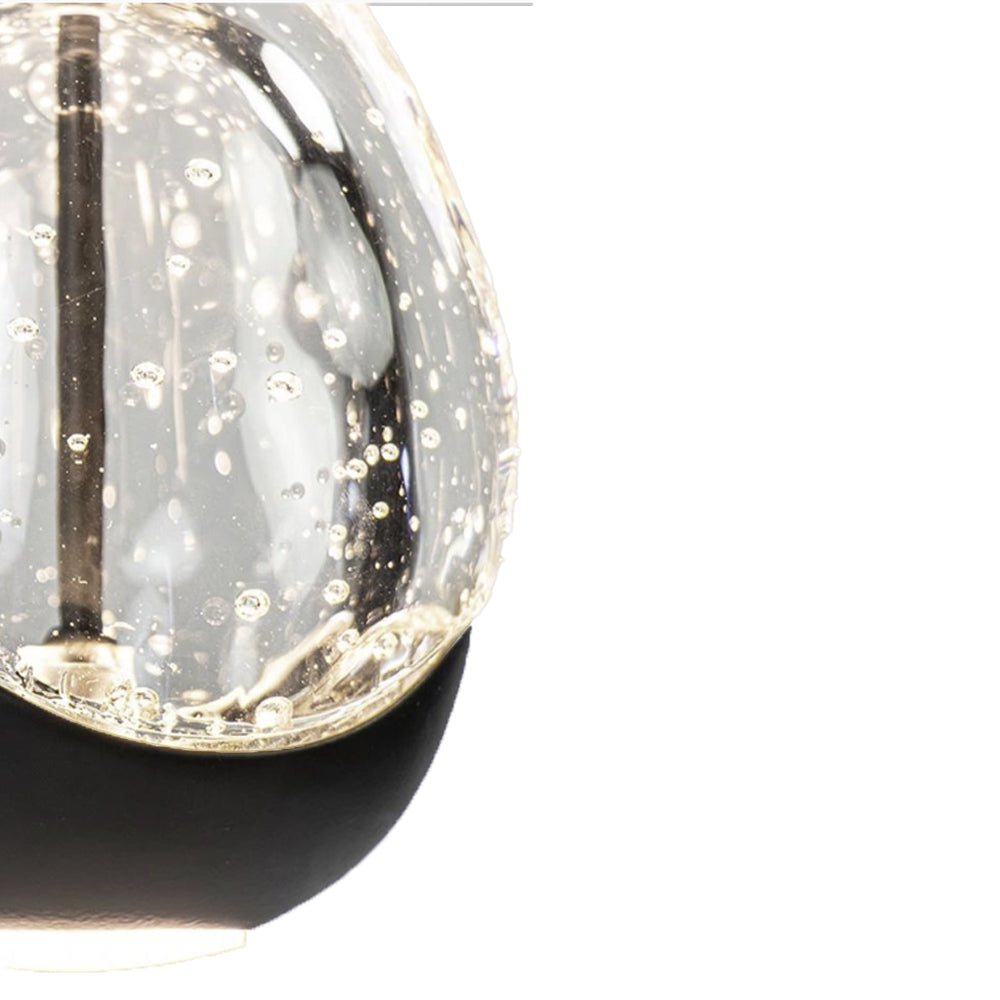Close-up vooraanzicht van een moderne glazen hanglamp met luchtbel-effect in het glas en zwarte basis, elegante en decoratieve verlichting voor interieur.