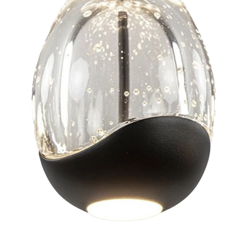 Close-up vooraanzicht van een moderne LED hanglamp met bubbeltjesglas en zwarte afwerking aan de onderzijde, waarin het licht subtiel naar beneden schijnt.