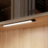 Moderne LED onderbouw verlichting gemonteerd onder een houten plank, zijaanzicht, ideaal voor boekenplanken, keukenkastjes of vitrines.