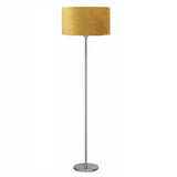 Staande lamp met moderne metalen voet en ronde okergele velours lampenkap, frontaal aanzicht tegen witte achtergrond.