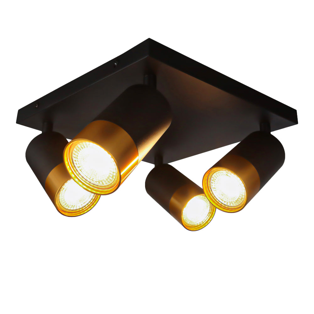 Zwarte plafondspot met vier verstelbare ronde spotlampen en goudkleurige accenten, schuin van onderen gefotografeerd met zicht op de onderzijde en zijkant van de lamp.