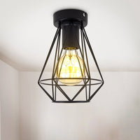 Industriële plafondlamp met zwart metalen draadframe en zichtbare filamentlamp, gefotografeerd in frontaal aanzicht tegen een wit plafond.